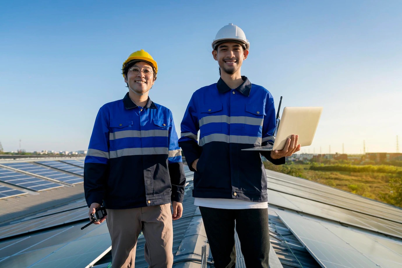 portrait-smiling-professional-engineer-with-laptop-tablet-maintenance-checking-installing-solar-roof-panel-factory-rooftop-sunlight-engineers-team-survey-check-solar-panel-roof_609648-2187